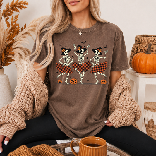 Woman wearing a brown t-shirt with skeleton design in a cozy indoor setting.